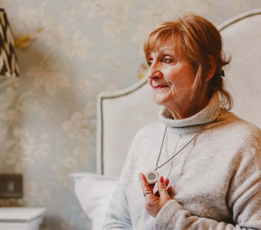 Elderly lady holding her pendant