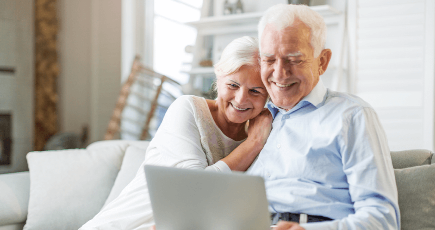 Two older people using laptop.