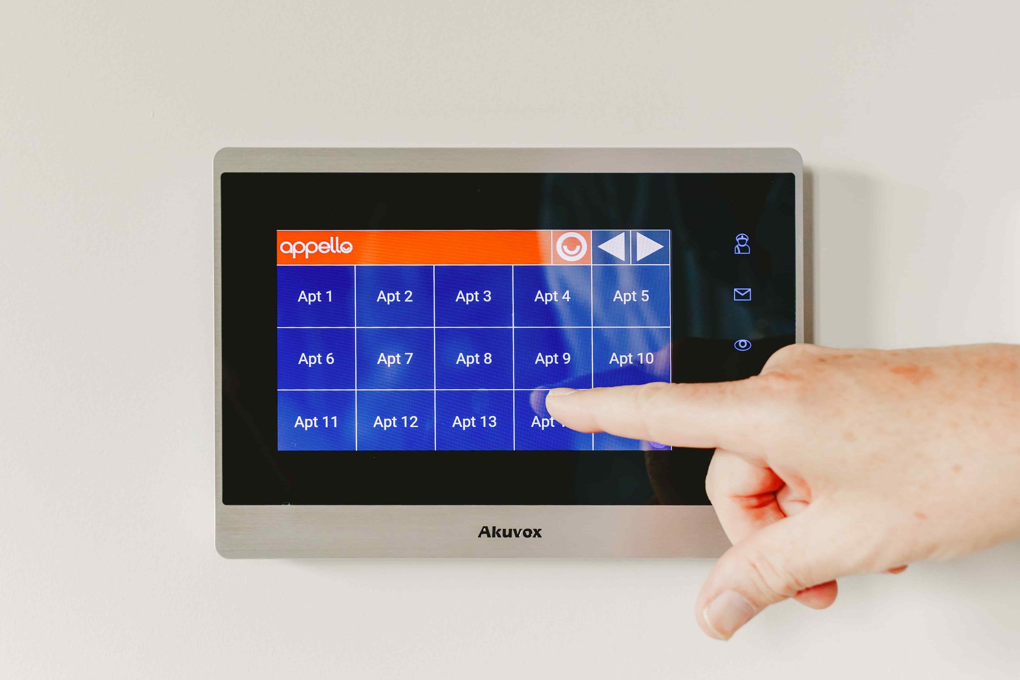 Elderly person pressing apartment button on warden call system.