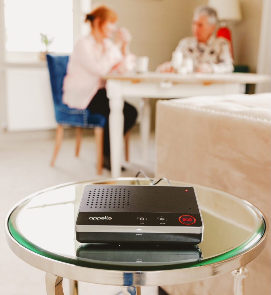 Elderly couple eating at dining table with SmartLife unit on side table